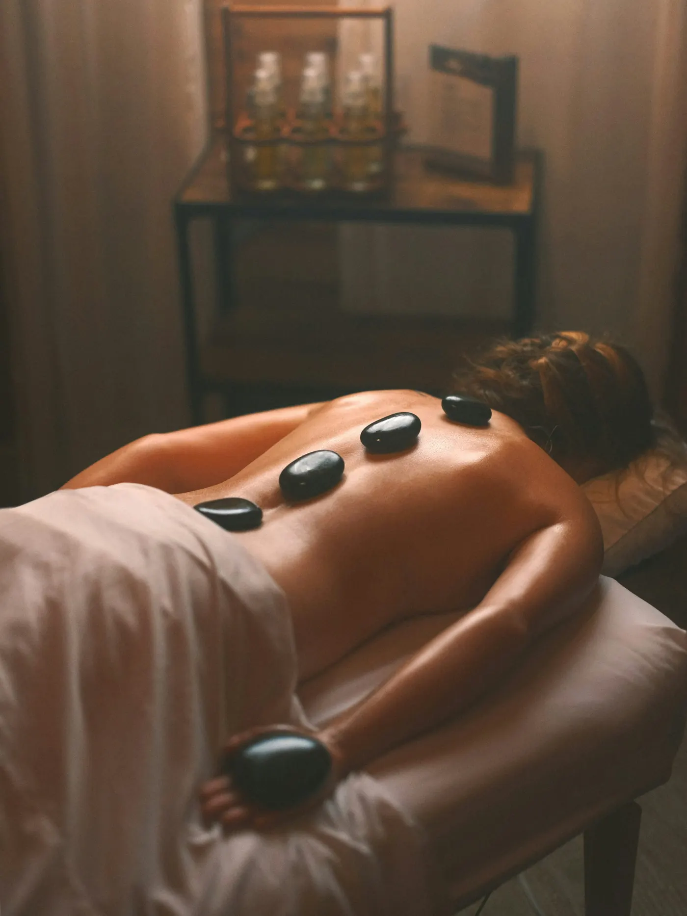 Luxurious spa setting with massage table, candles, and essential oils